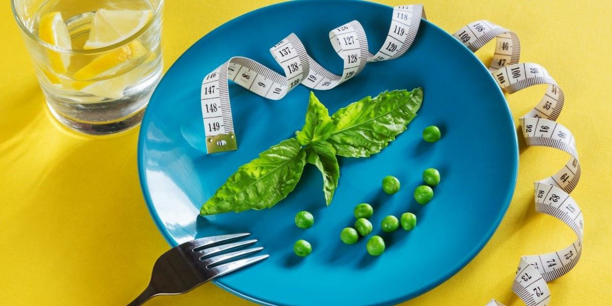 blue plate topped with green vegetables and measuring tape