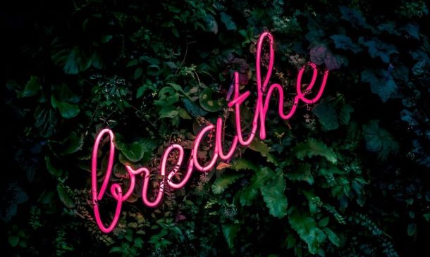 breathe sign in pink neon writing