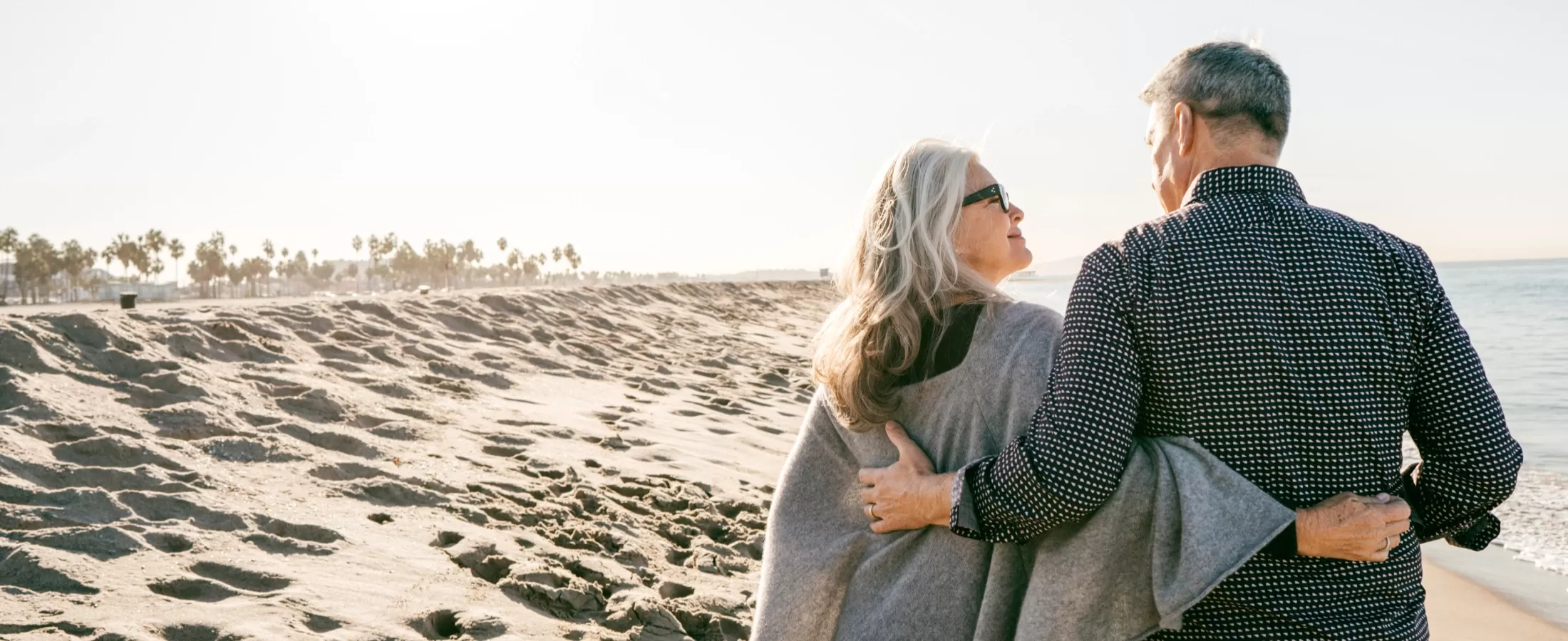 Retired couple walking along the beach