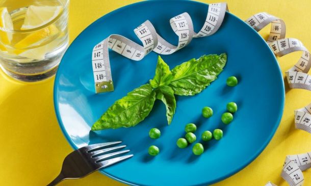 blue plate topped with green vegetables and measuring tape