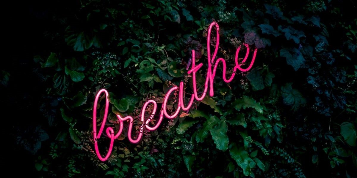 breathe sign in pink neon writing