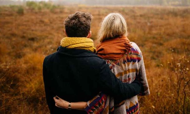 Rugged up couple sitting outside in the country on a cold day