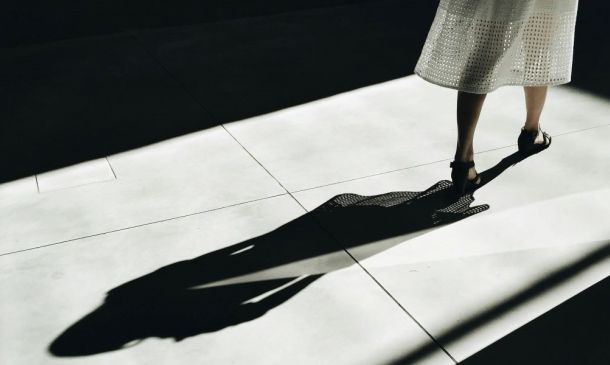 woman walking away with a shadow behind her